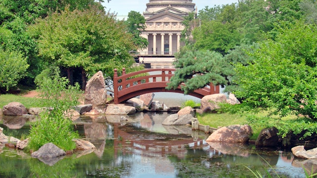 Japanese bridge at Osaka Garden in Jackson Park. The Museum of Science and Industry is in the background.