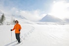 Woman wearing snow shoes, Skidadalur, Dalvik, Iceland.