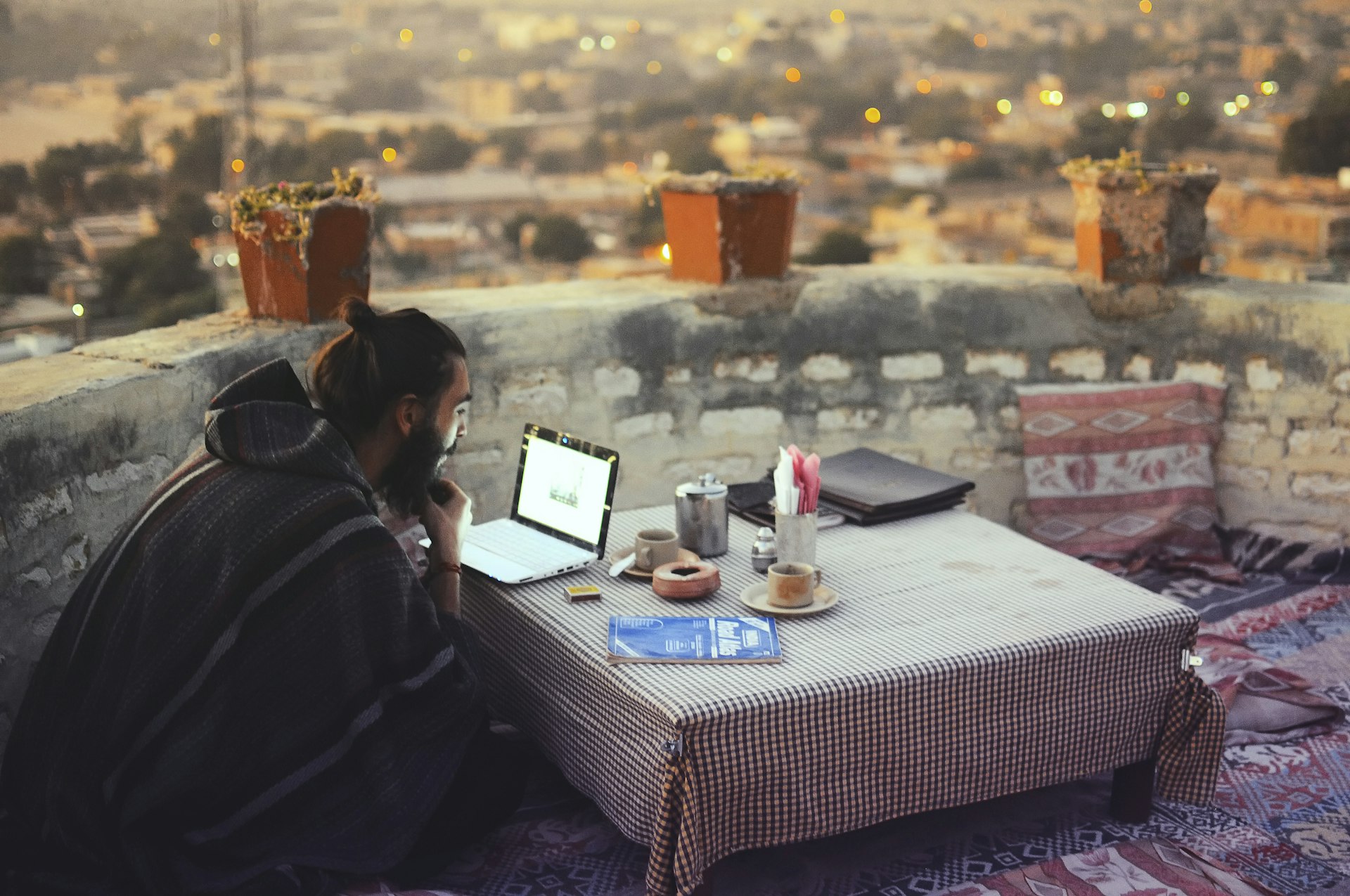 Man working on a laptop on top of an ancient fortress in Jaisalmer