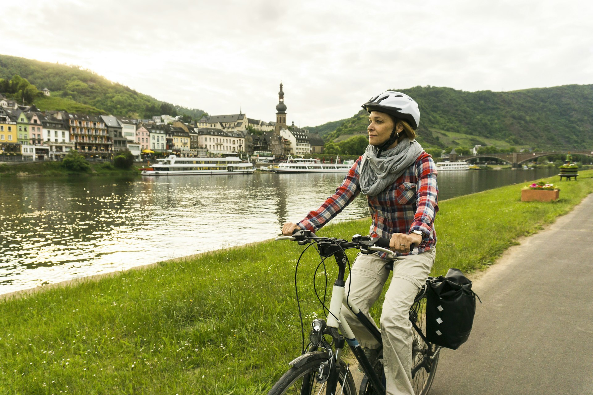 Woman riding bicycle along a riverside 