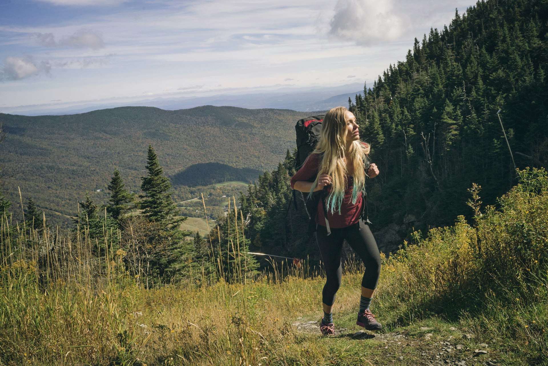 Woman hiking on a rocky ridgeline in Stowe, Vermont