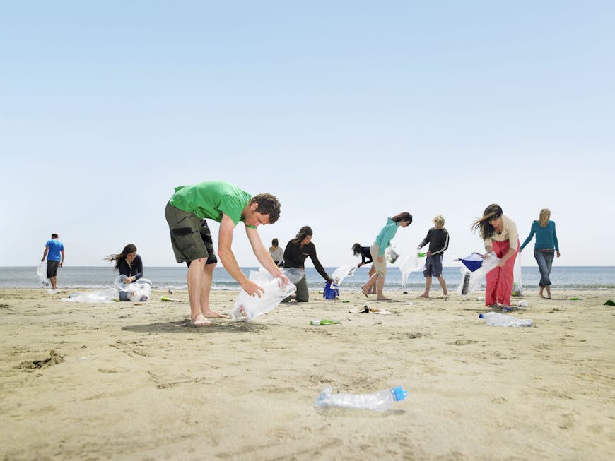 Young people collecting garbage on beach