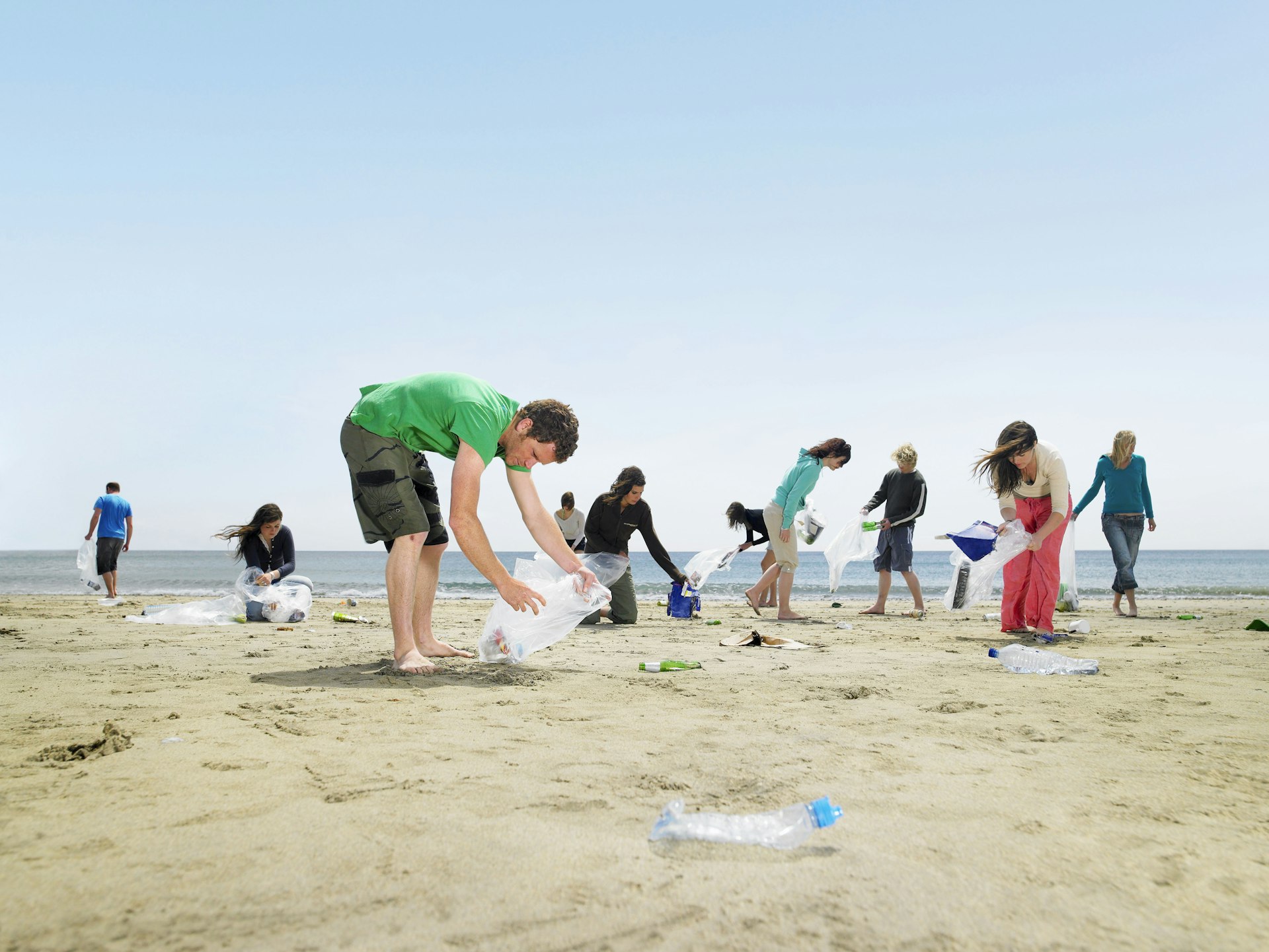 Young people collecting garbage on beach