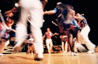 Blurred square dancers dancing in a circle at Grand Ole Opry concert hall.
