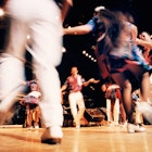 Blurred square dancers dancing in a circle at Grand Ole Opry concert hall.