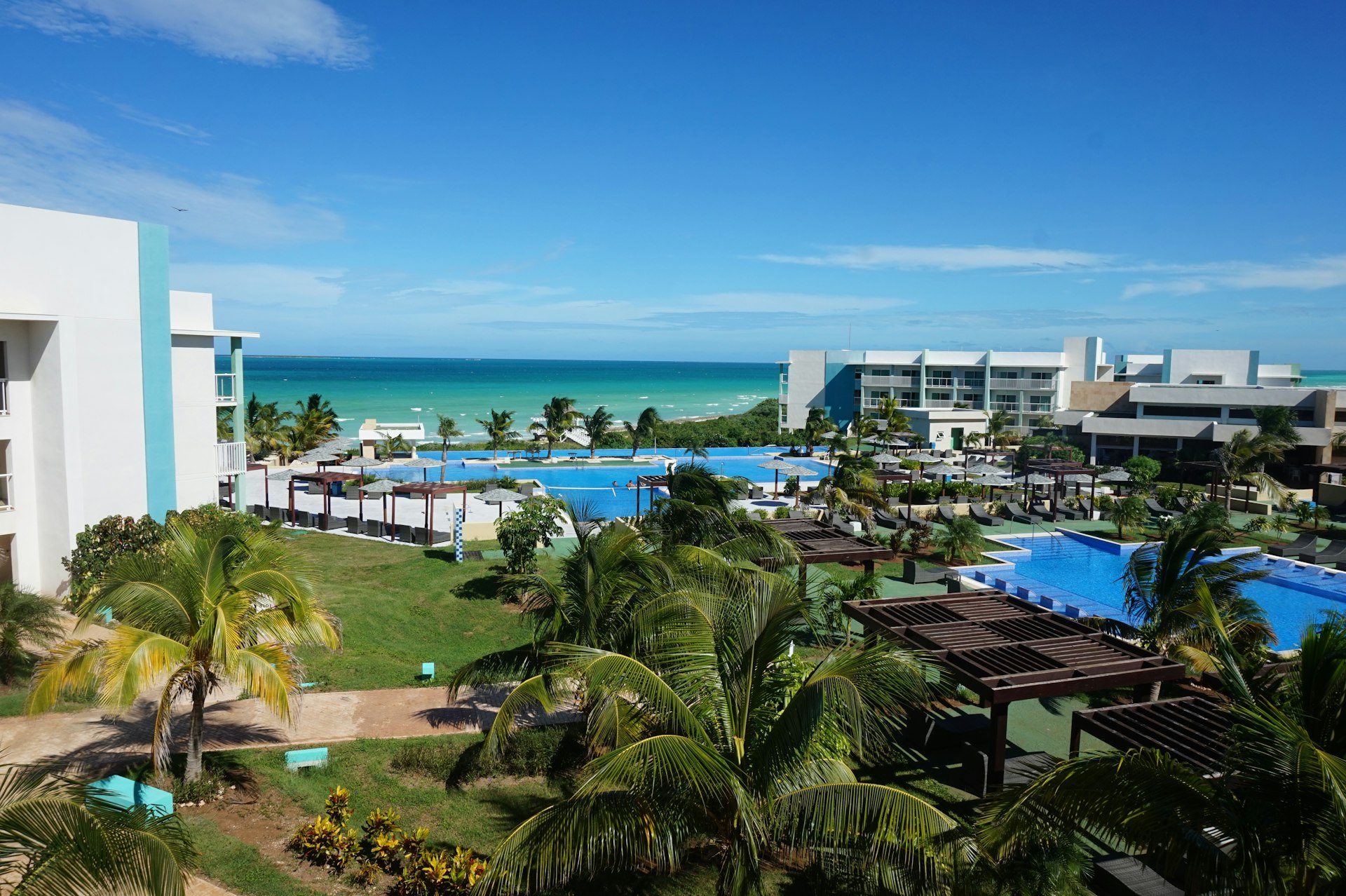 An empty resort courtyard, with pool and beach in the background