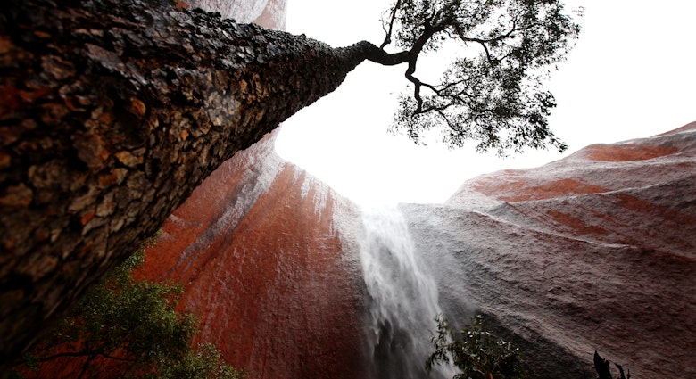 ULURU-KATA TJUTA NATIONAL PARK, AUSTRALIA - NOVEMBER 28: A waterfall is seen in Kantju Gorge as it rains at Uluru on November 28, 2013 in Uluru-Kata Tjuta National Park, Australia. Uluru/ Ayers Rock is a large sandstone formation situated in central Australia approximately 335km from Alice Springs. The site and its surrounding area is scared to the Anangu people, the Indigenous people of this area and is visited by over 250,000 people each year.  (Photo by Mark Kolbe/Getty Images)