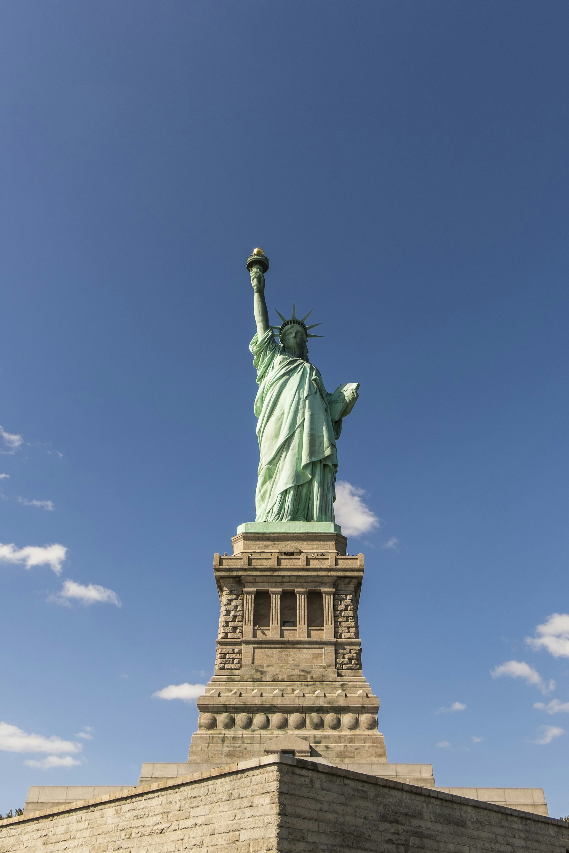 Vertical image of the Statue of Liberty and a bright blue sky 