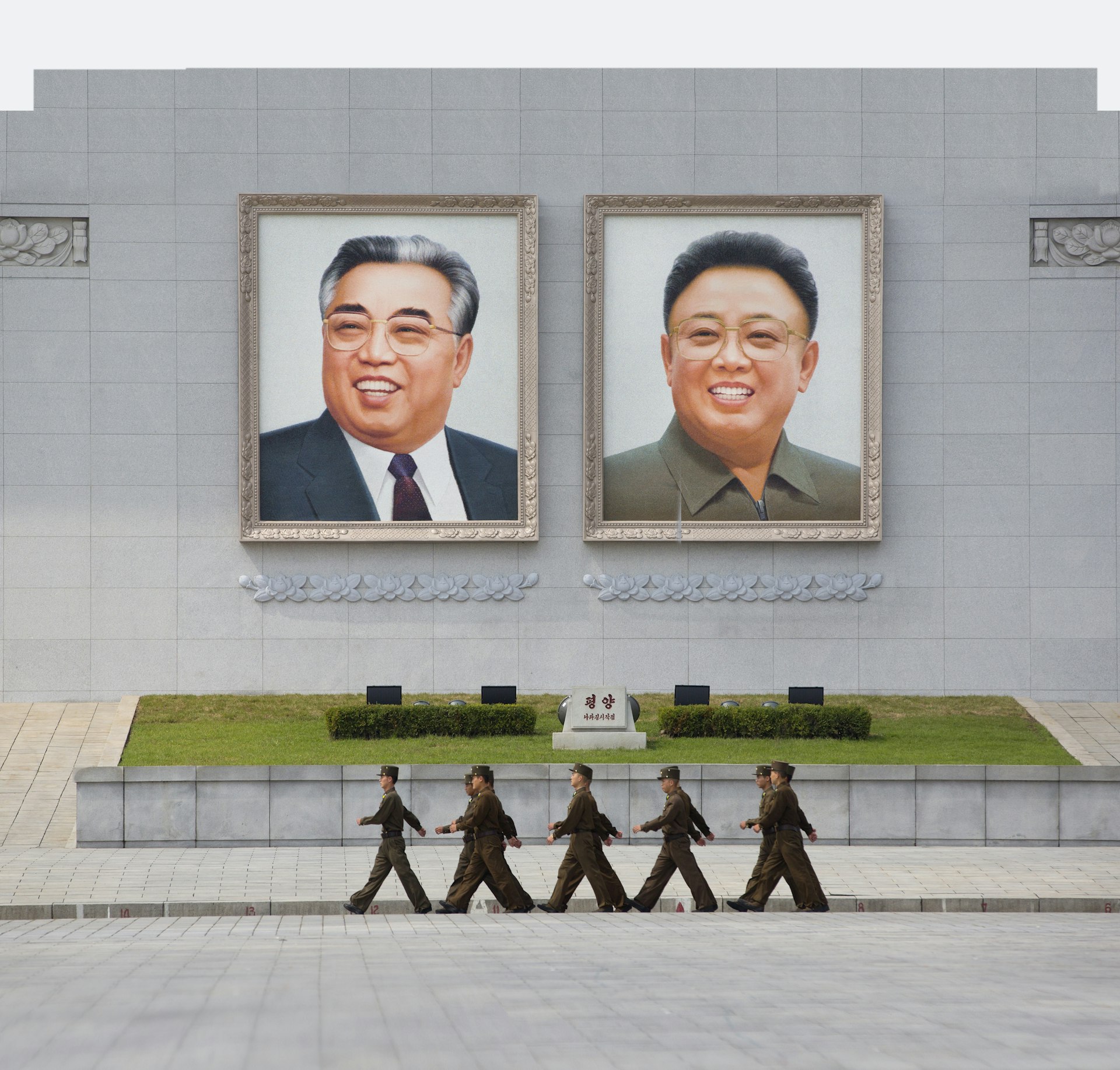 People's Army soldiers marching in front of giant portraits of Kim Il Sung and Kim Jong Il on Kim Il Sung Square