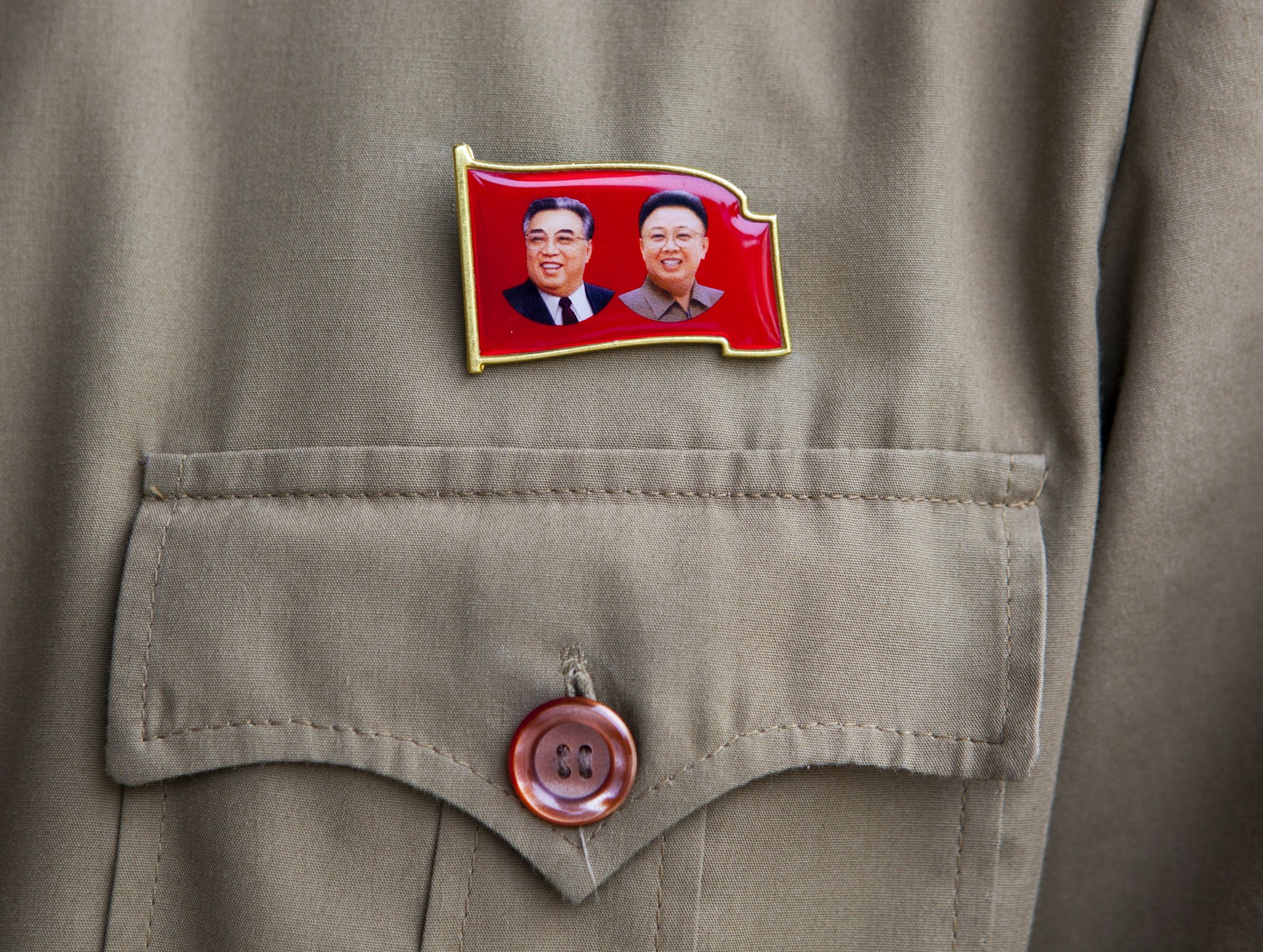 A pin in the shape of a red flag with Kim Jong-il and Kim Il-sung
