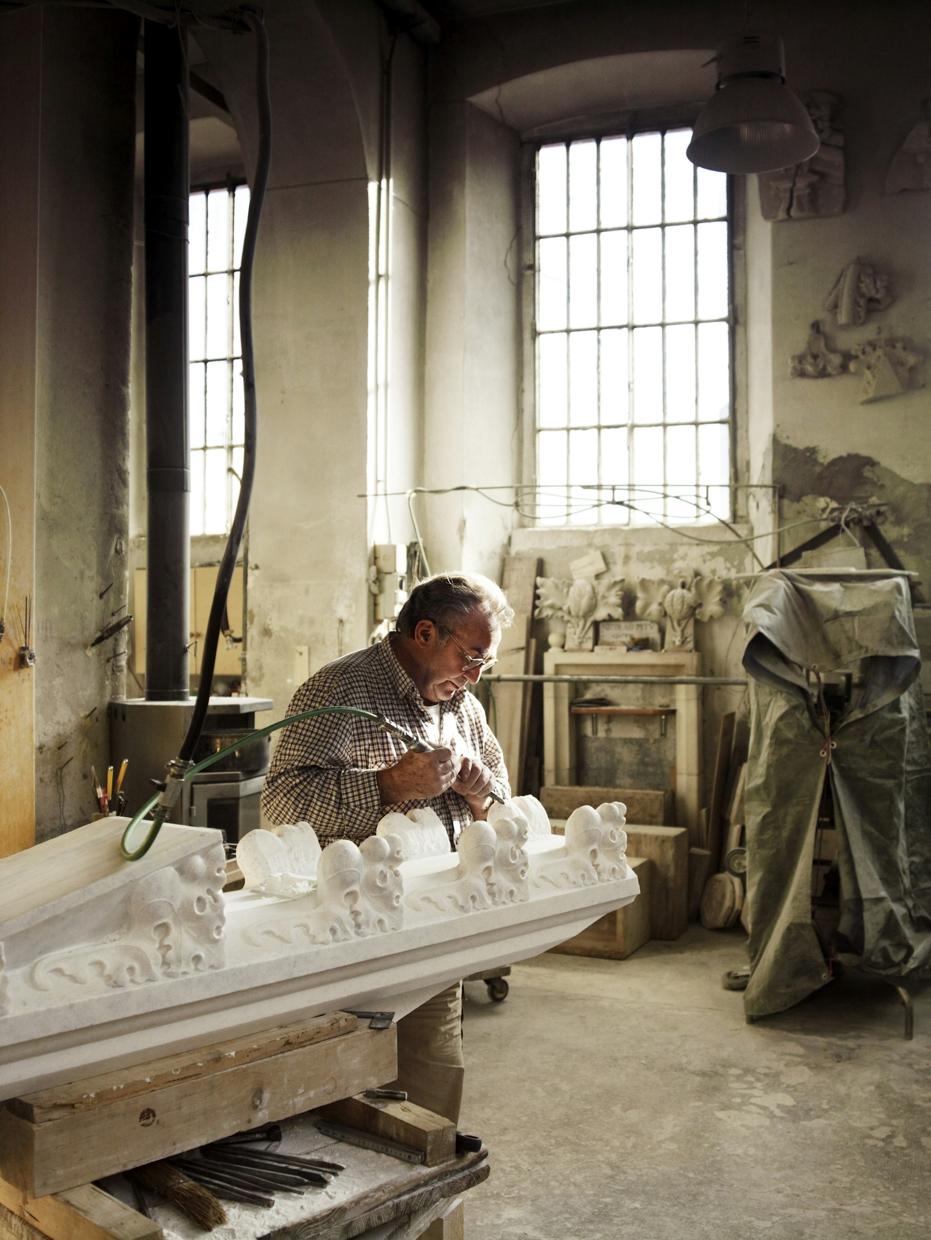 Craftsman sculpting Candoglia marble in workshop