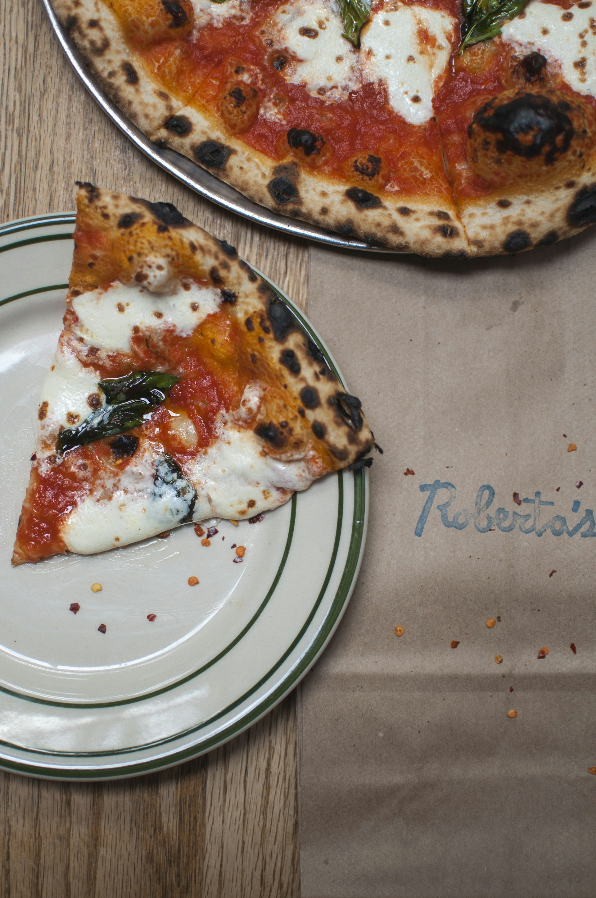 A slice of margherita pizza with lightly charred crust 