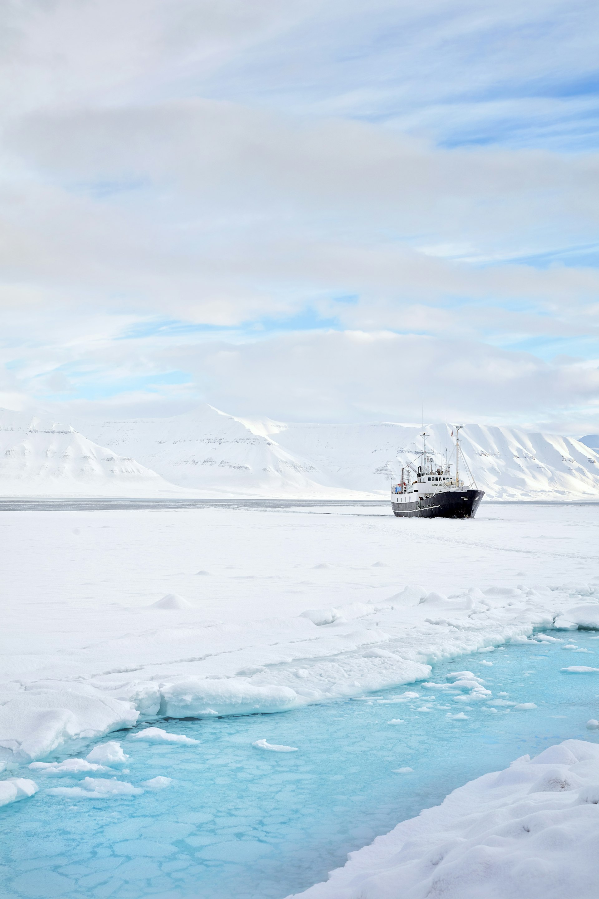 A boat surrounded by ice and snowy mountains