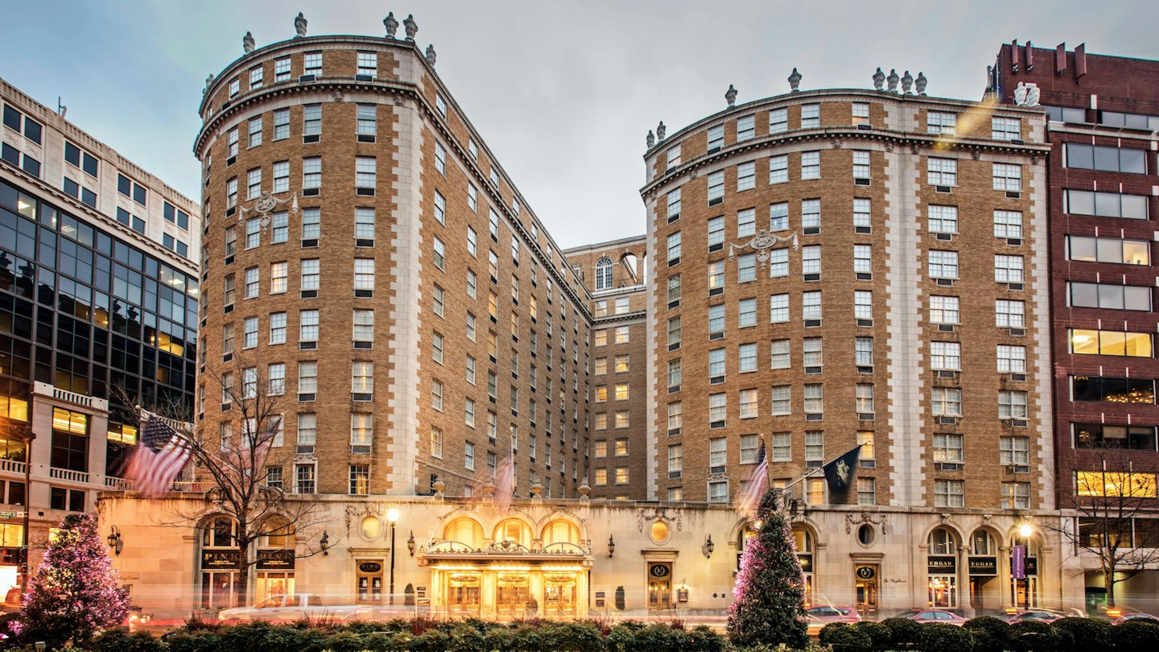 An elegant brick exterior of a large hotel building with two curved facades