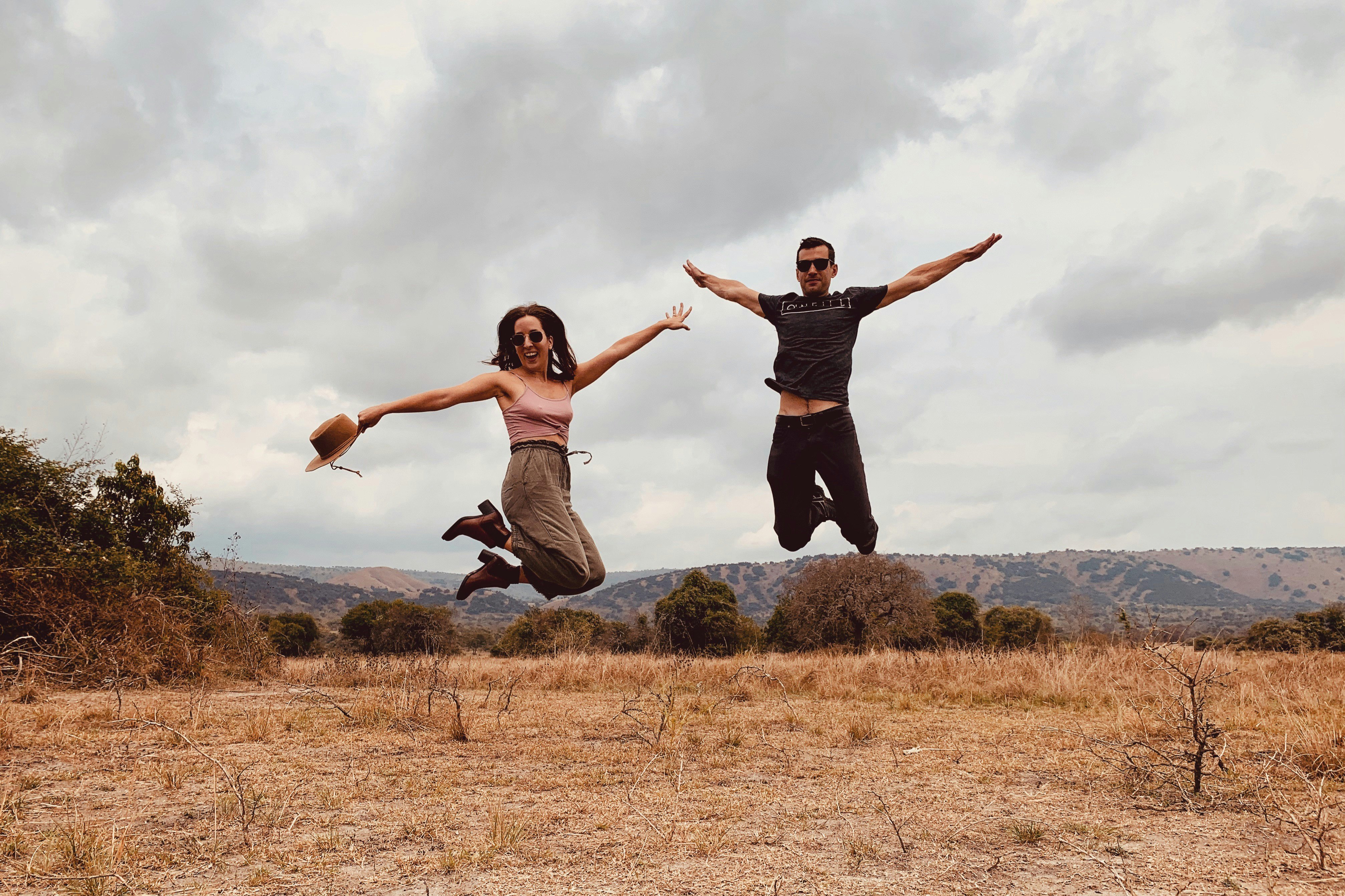 Melany and Corey Rabideau jumping in the air on a beach