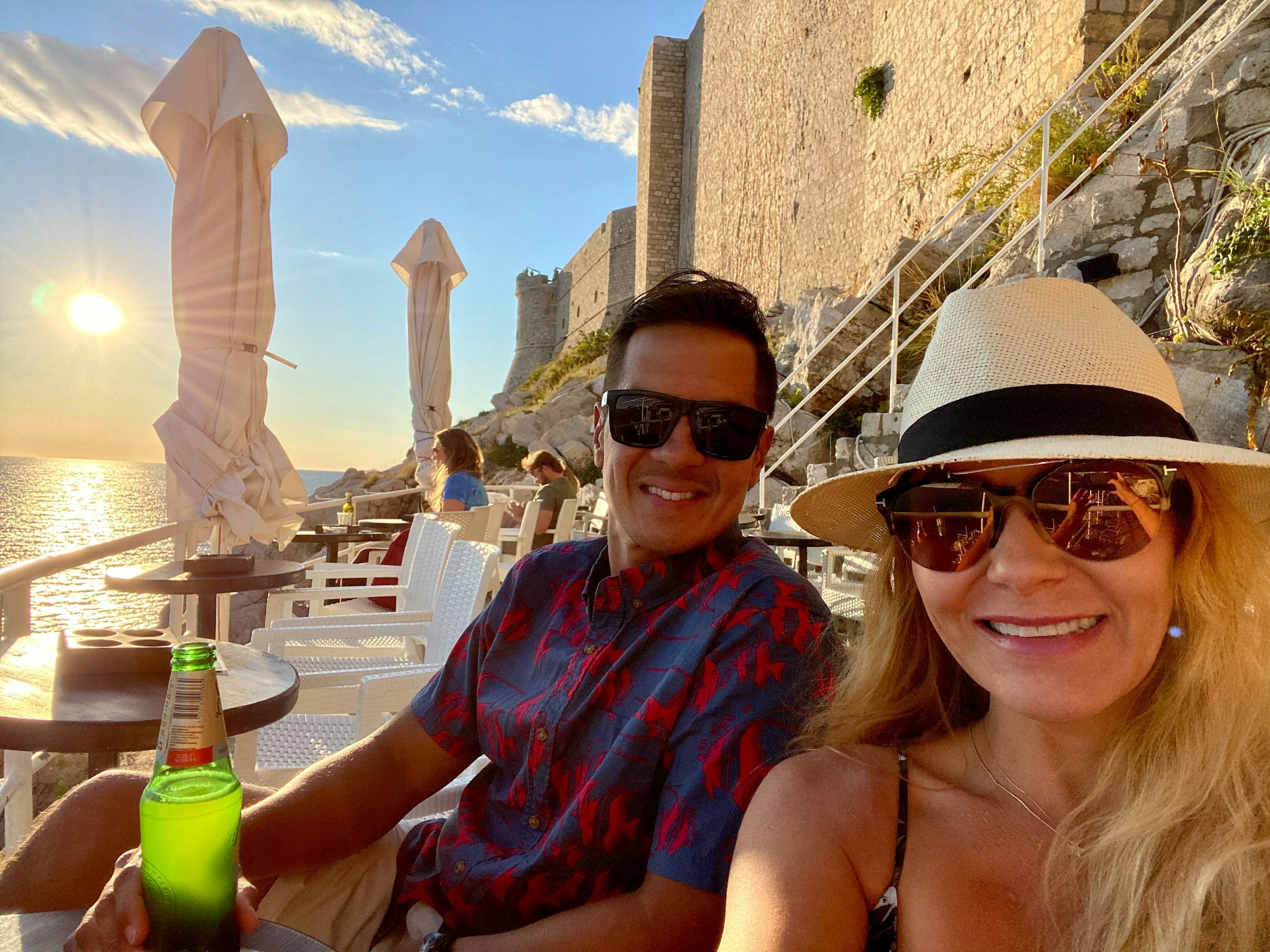 A man and woman sitting in front of ruins in Dubrovnik