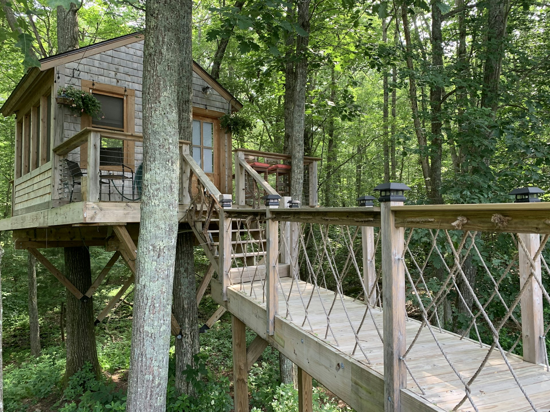 A wooden walkway leads to the entrance of a tree house in Richmond, Rhode Island