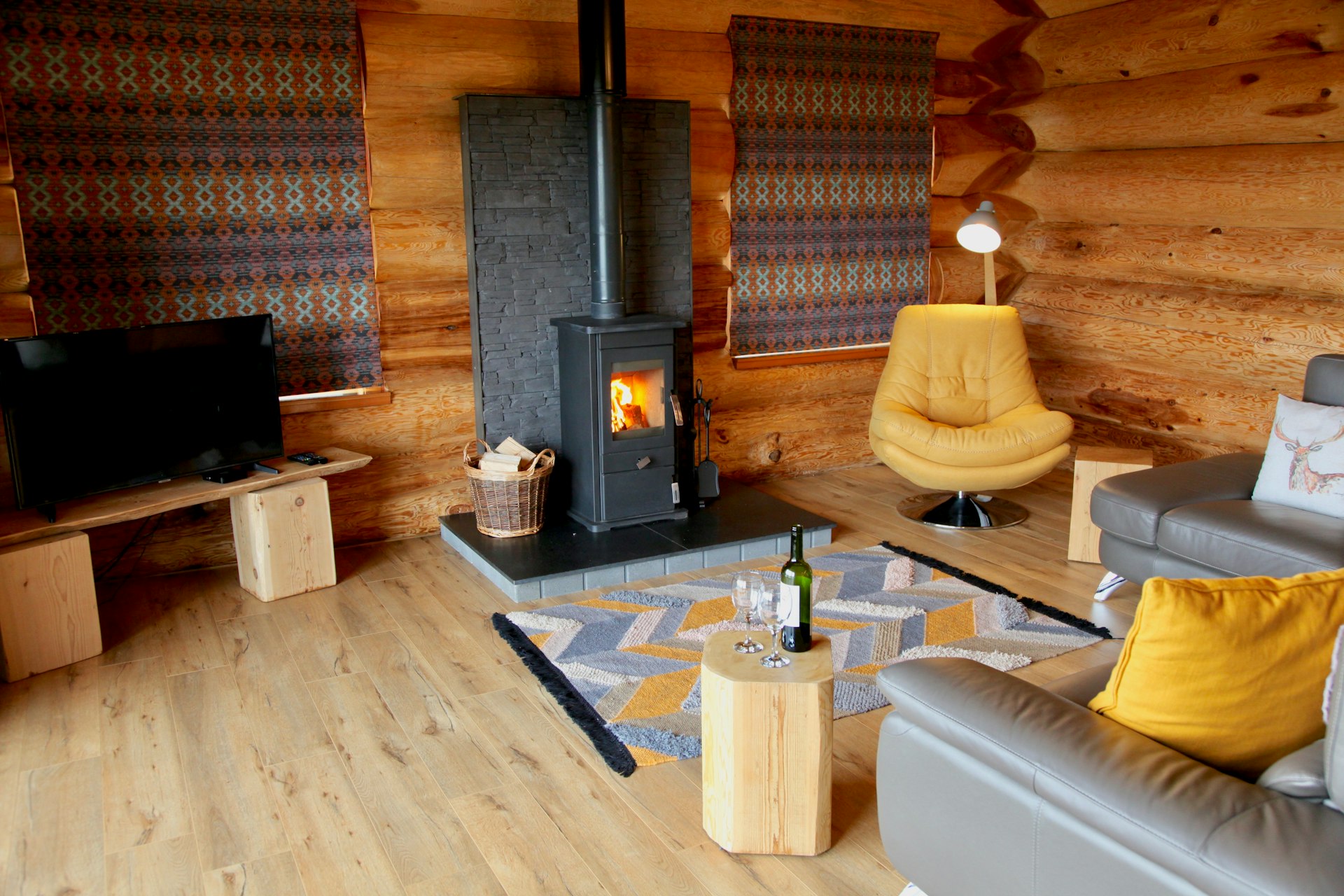 Interior shot of a luxury log cabin, with leather sofas and a wood burner