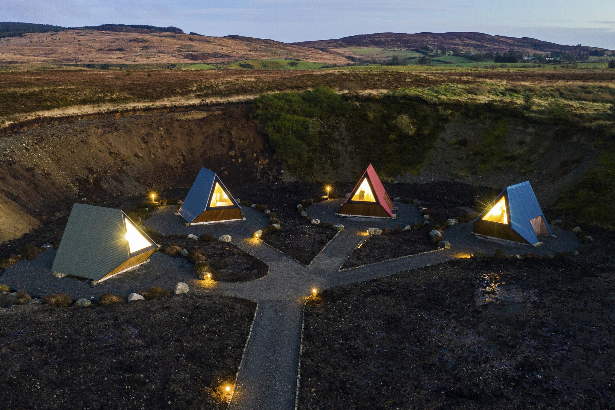 Four separate triangular pods lit up in a crater-like landscape