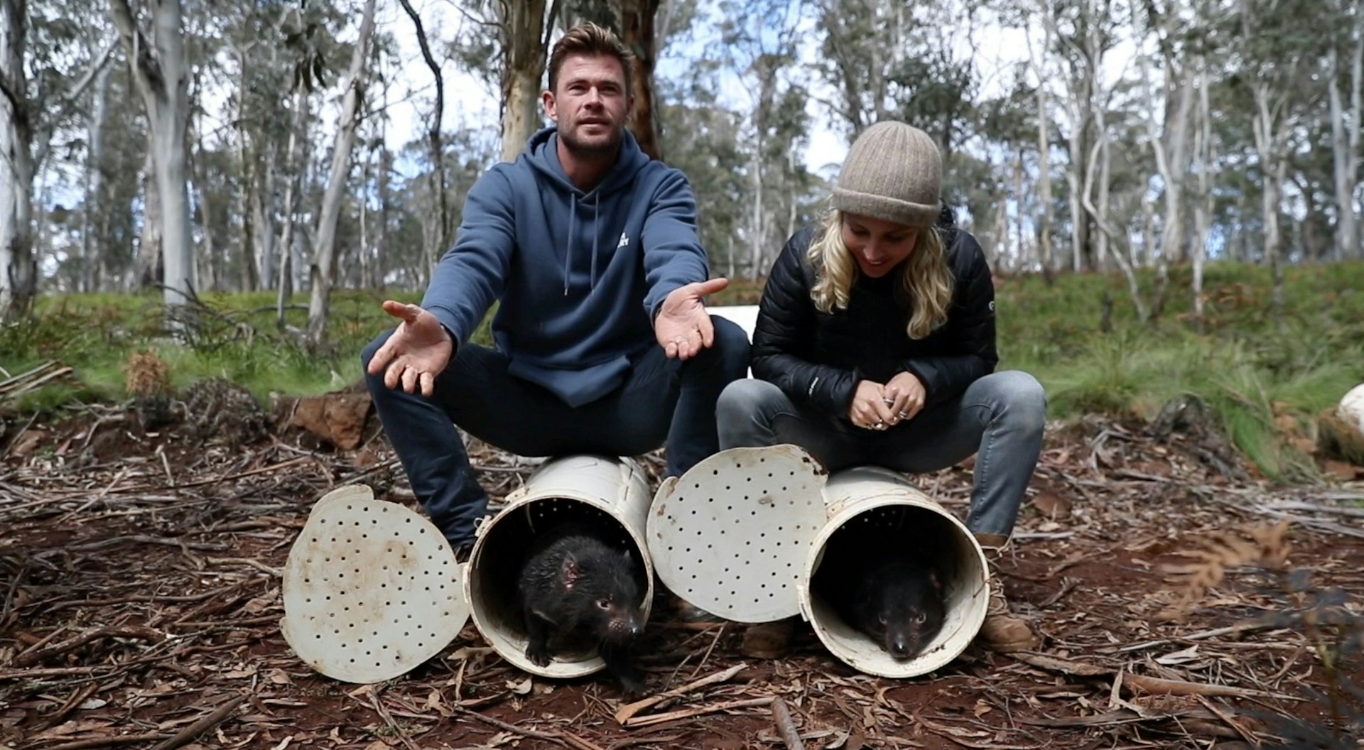 Chris Hemsworth and Elsa Pataky releasing Tasmanian Devils into the wild from safety tubes