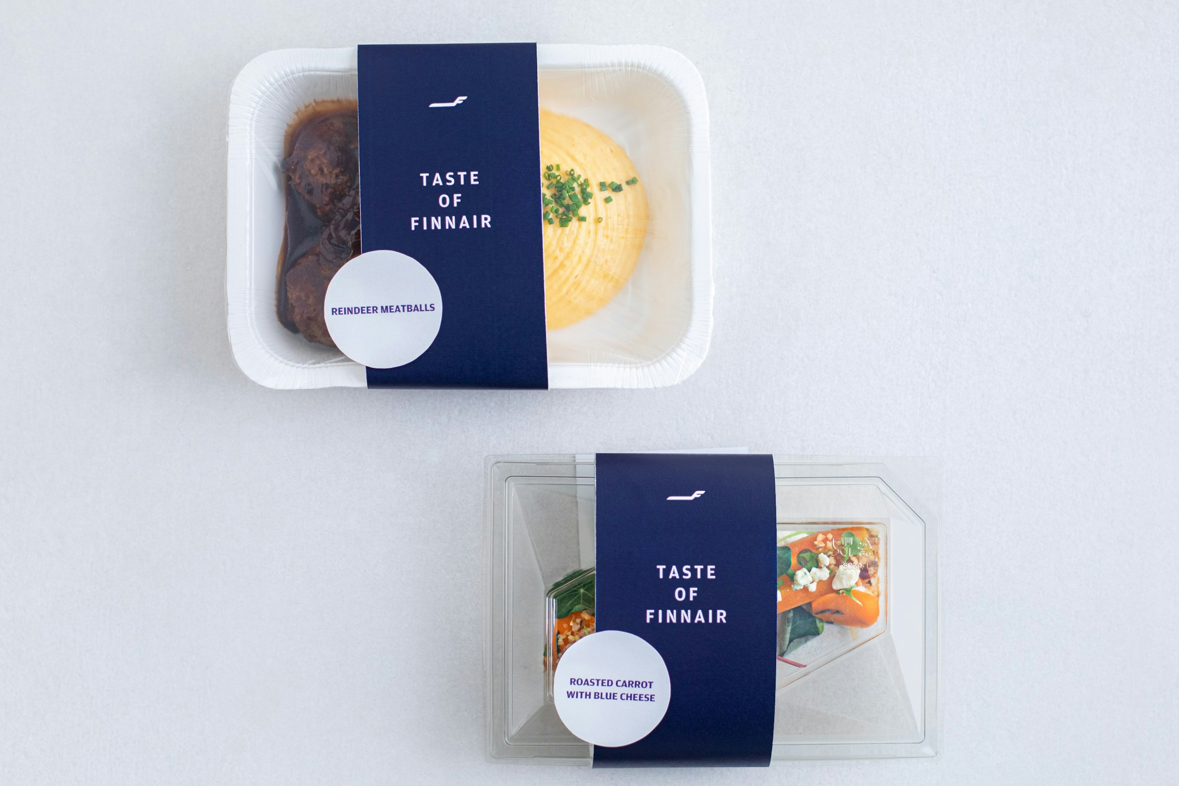 Two airline meals in polystyrene cartons