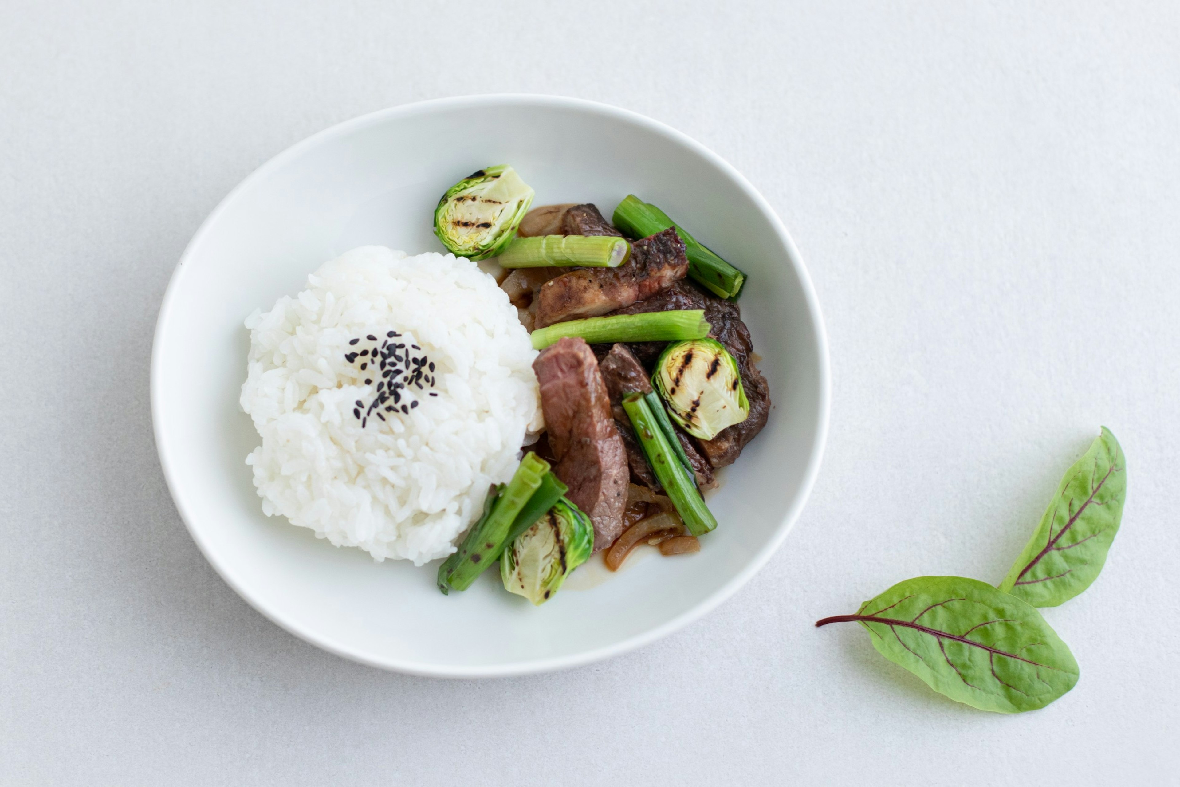 An airline meal in a bowl on a white background