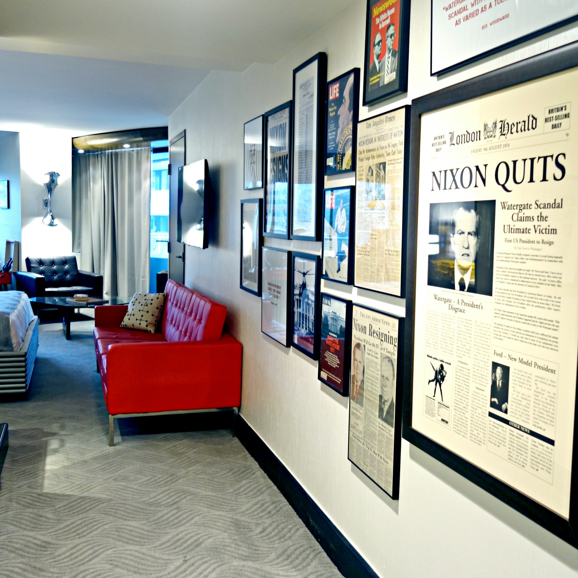 A room with a large framed newspaper page mounted on the wall. The headline says "Nixon quits"