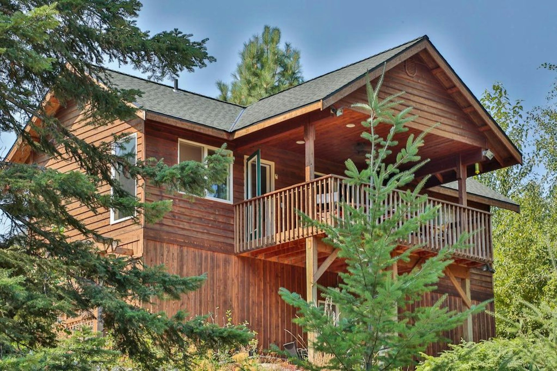 A cabin on a hill, partially obscured by tree branches