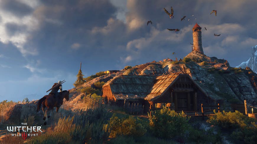 Geralt rider sin häst uppför en kulle mot en ensam fyr i en skärmdump från spelet The Witcher 3: Wild Hunt