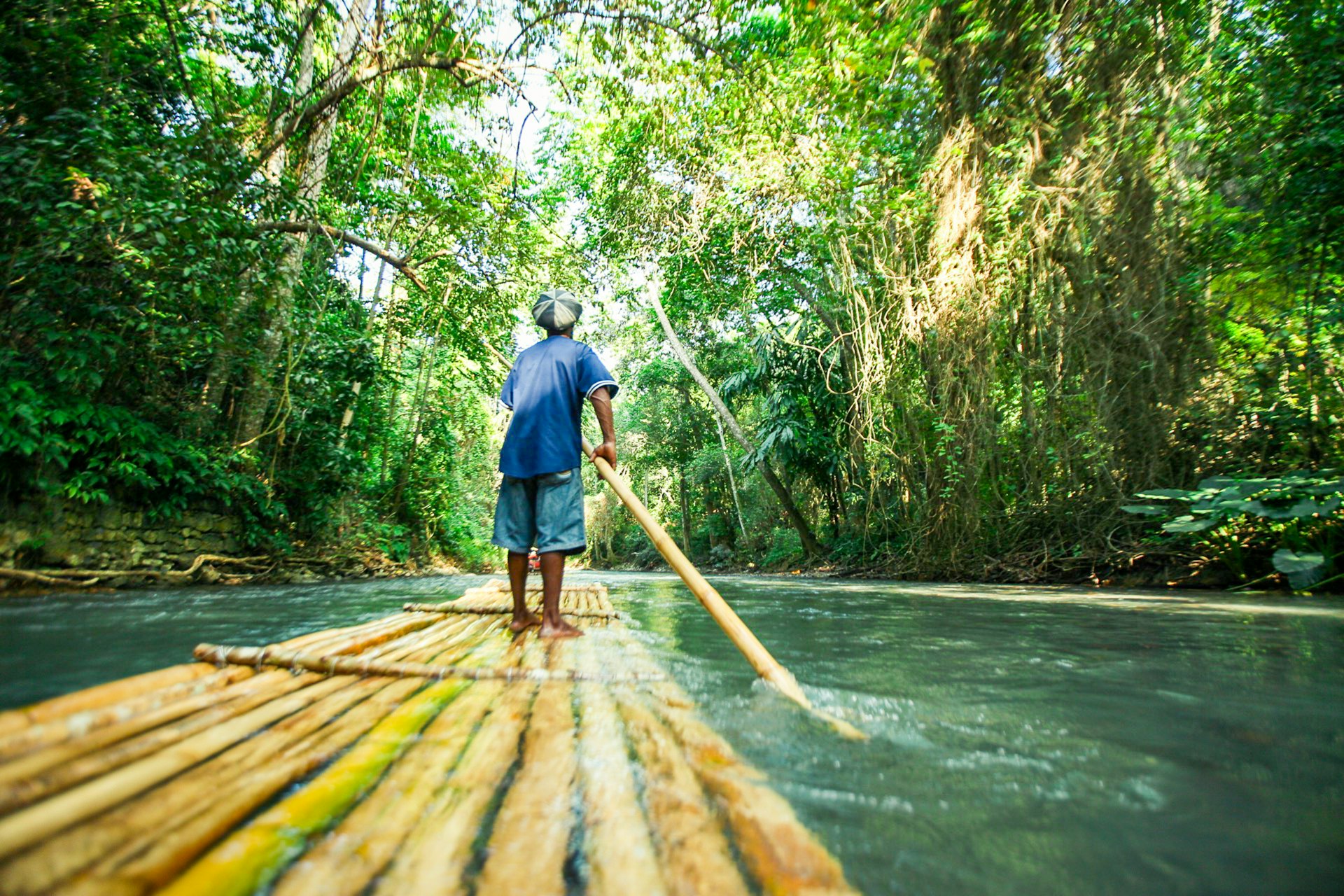 A man river rafting in the forest of Jamaica