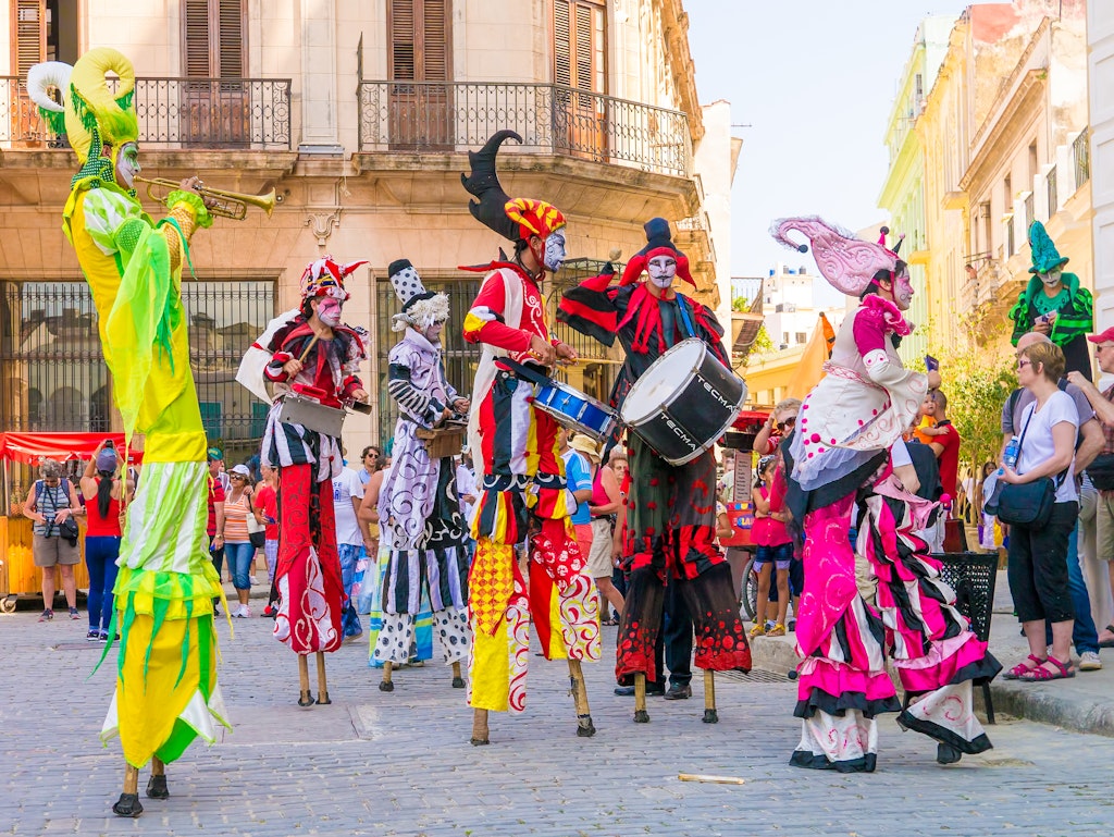 HAVANA, CUBA - APRIL 15,2015 : Colorful stiltwalkers dancing to the sound of cuban music in Old Havana.