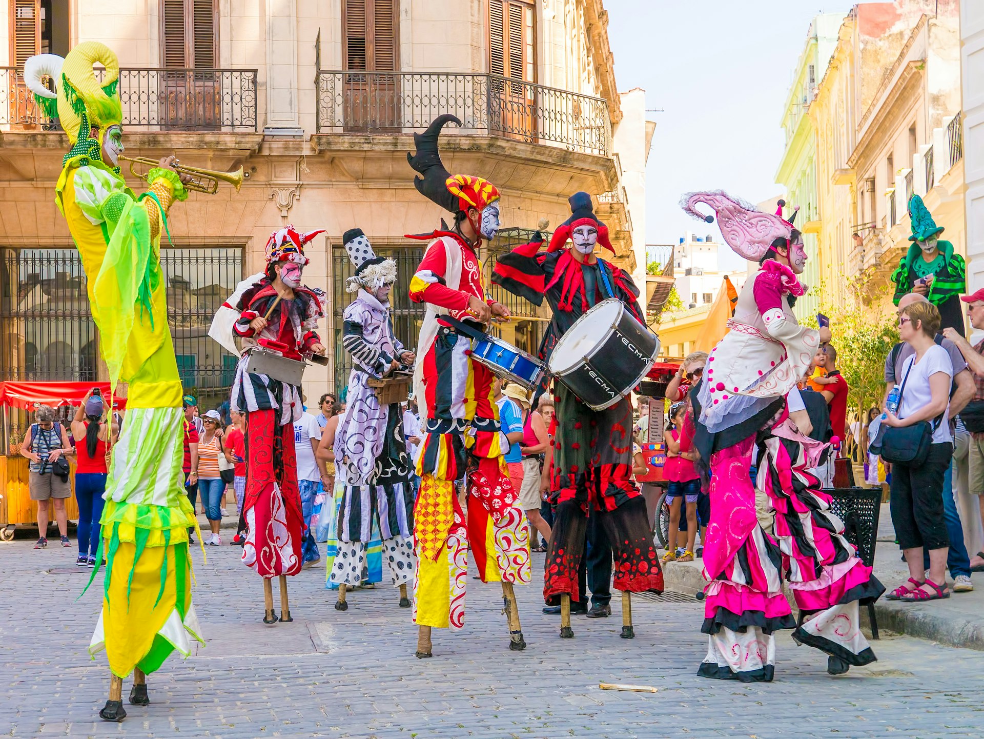 Colorful stiltwalkers dancing to the sound of cuban music in Old Havana