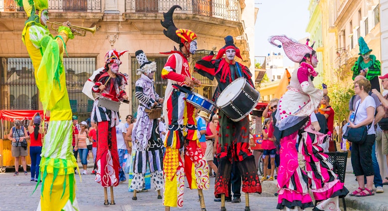 HAVANA, CUBA - APRIL 15,2015 : Colorful stiltwalkers dancing to the sound of cuban music in Old Havana.