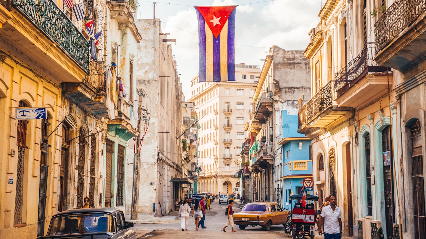 December 2015: A Cuban flag hangs over a busy street in Central Havana.