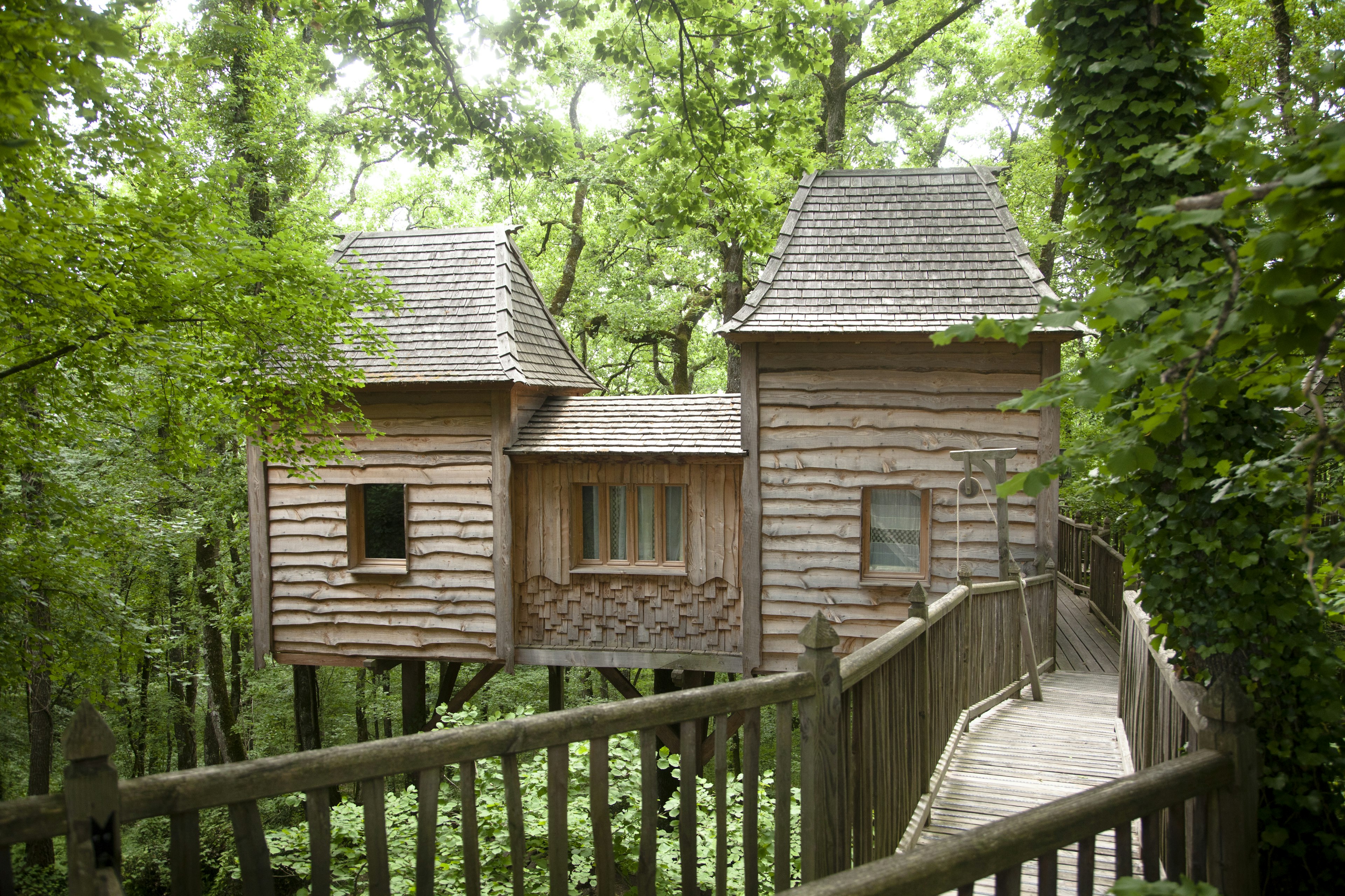 Wooden tree house with walkway in dense woodland