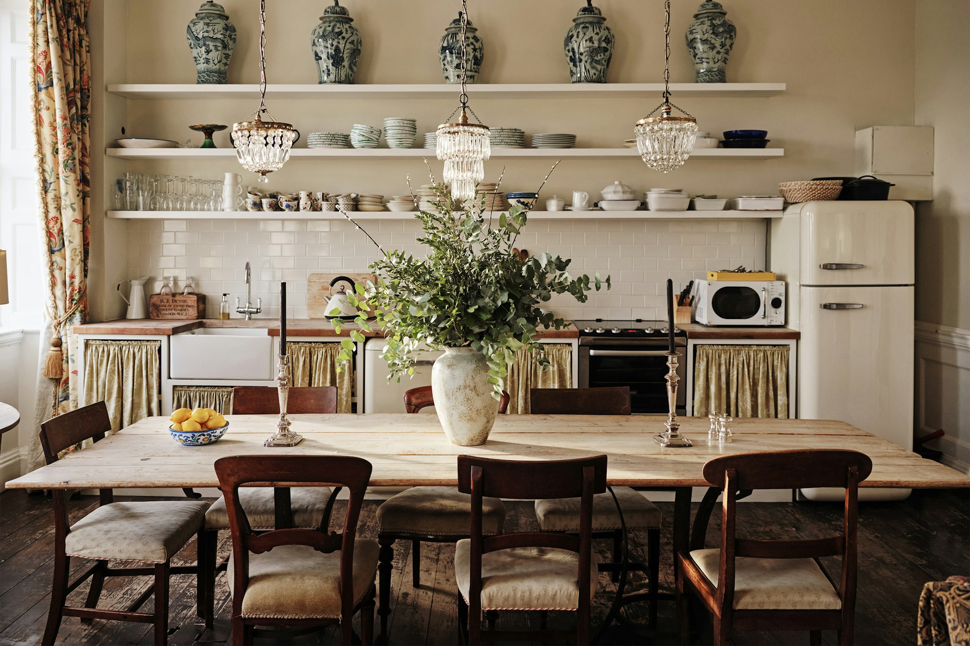 A kitchen with open shelving and a big dining table