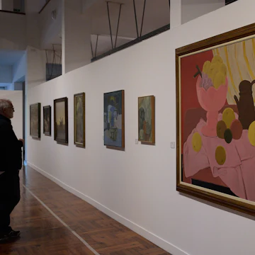A visitor looks at a painting by Colombian artist Fernando Botero during an exhibition of painters from Uruguay, Mexico and Colombia at the Museum of Visual Arts in Montevideo on March 22, 2018. / AFP PHOTO / Miguel ROJO (Photo credit should read MIGUEL ROJO/AFP/Getty Images)