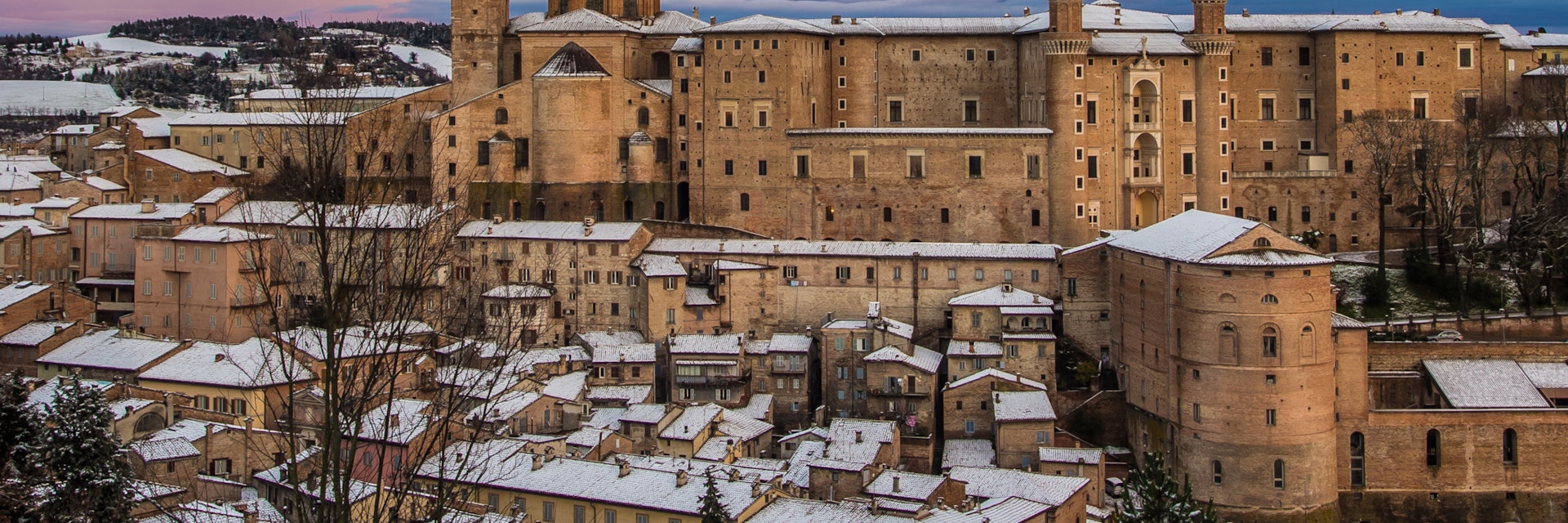Beautiful colored sky over Urbino at sunset with snow.