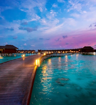 Oversea resort huts at end of long jetty, Maldives