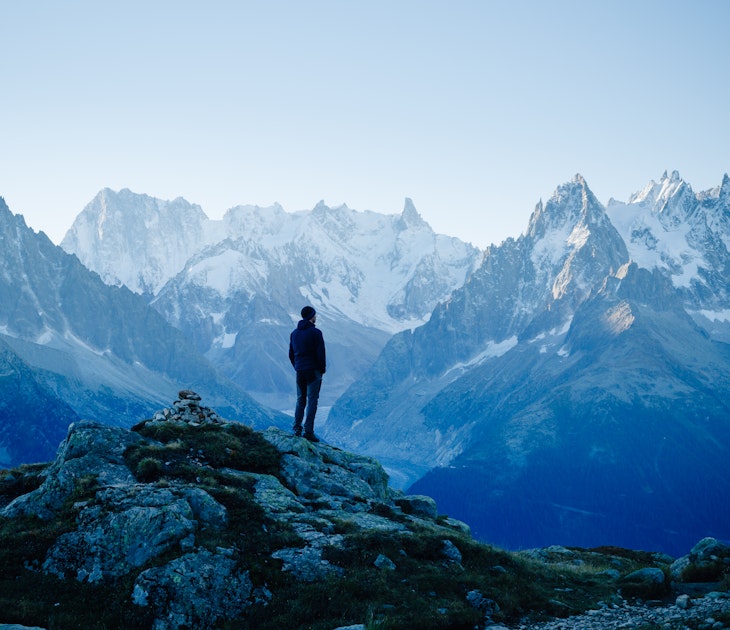 A hiker standing in the mountains above Chamonix in early morning light..