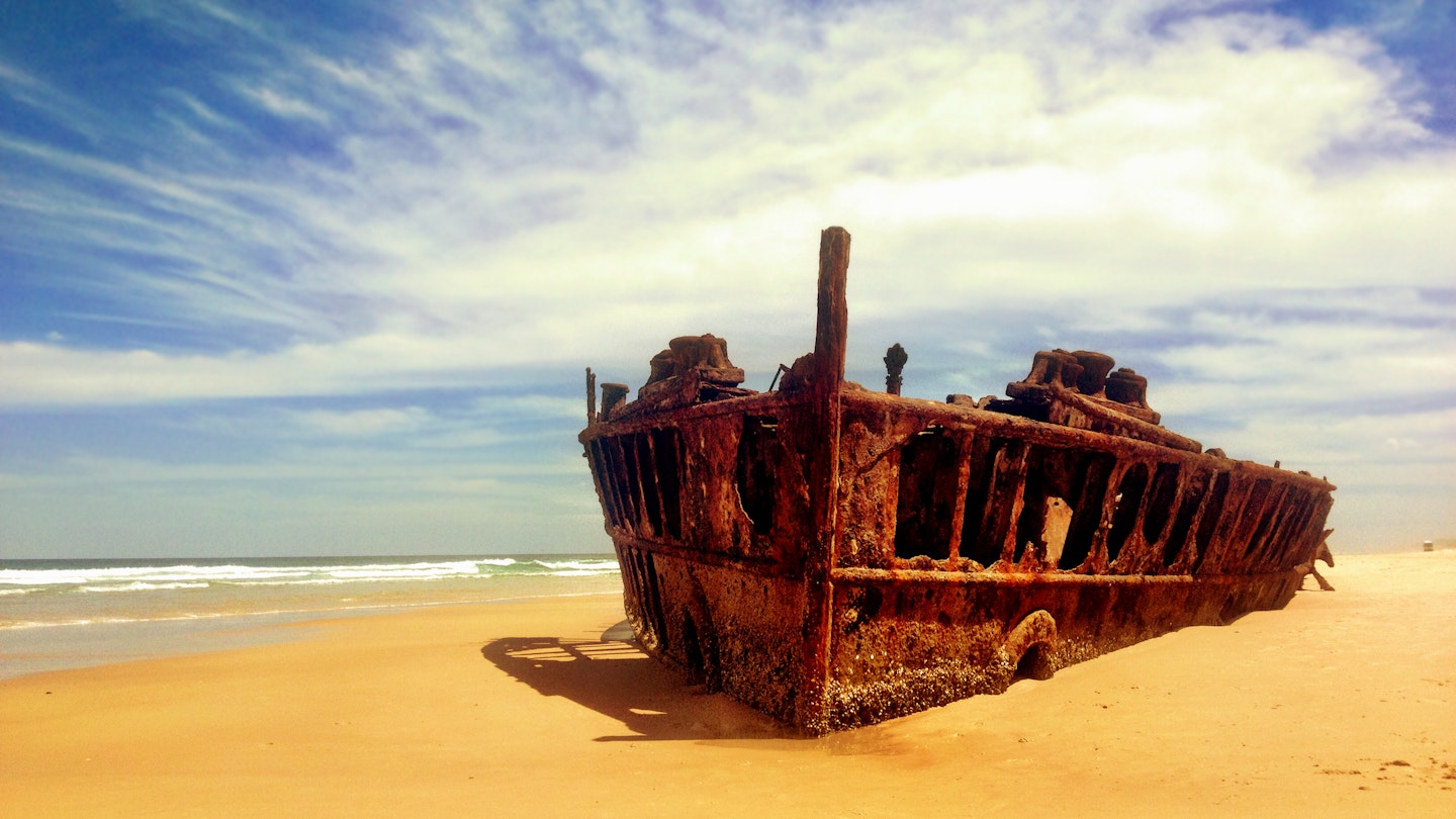 Rusted shipwreck on beach of Fraser Island.