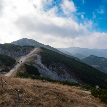 People walk on the path at Untersberg with cloudy sky in Salzburg, Austria.