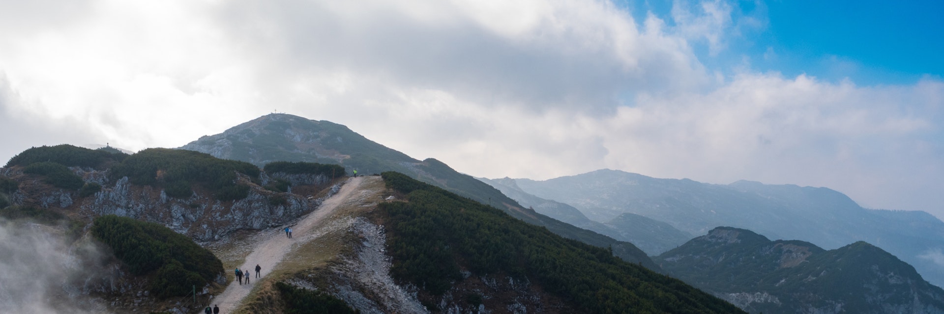 People walk on the path at Untersberg with cloudy sky in Salzburg, Austria.