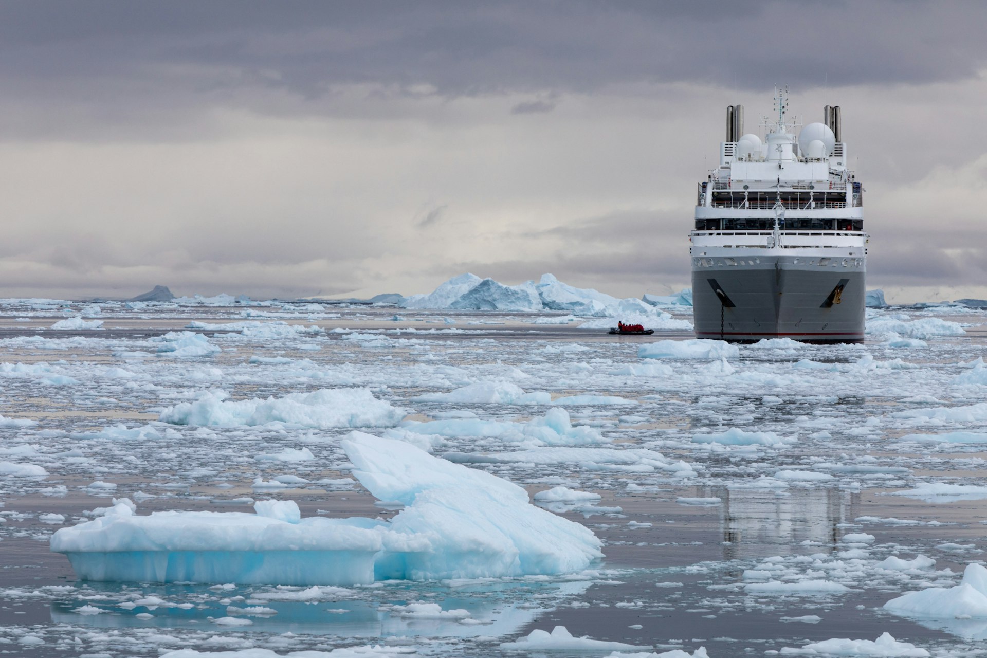 A large ship navigates the icy waters of the Arctic
