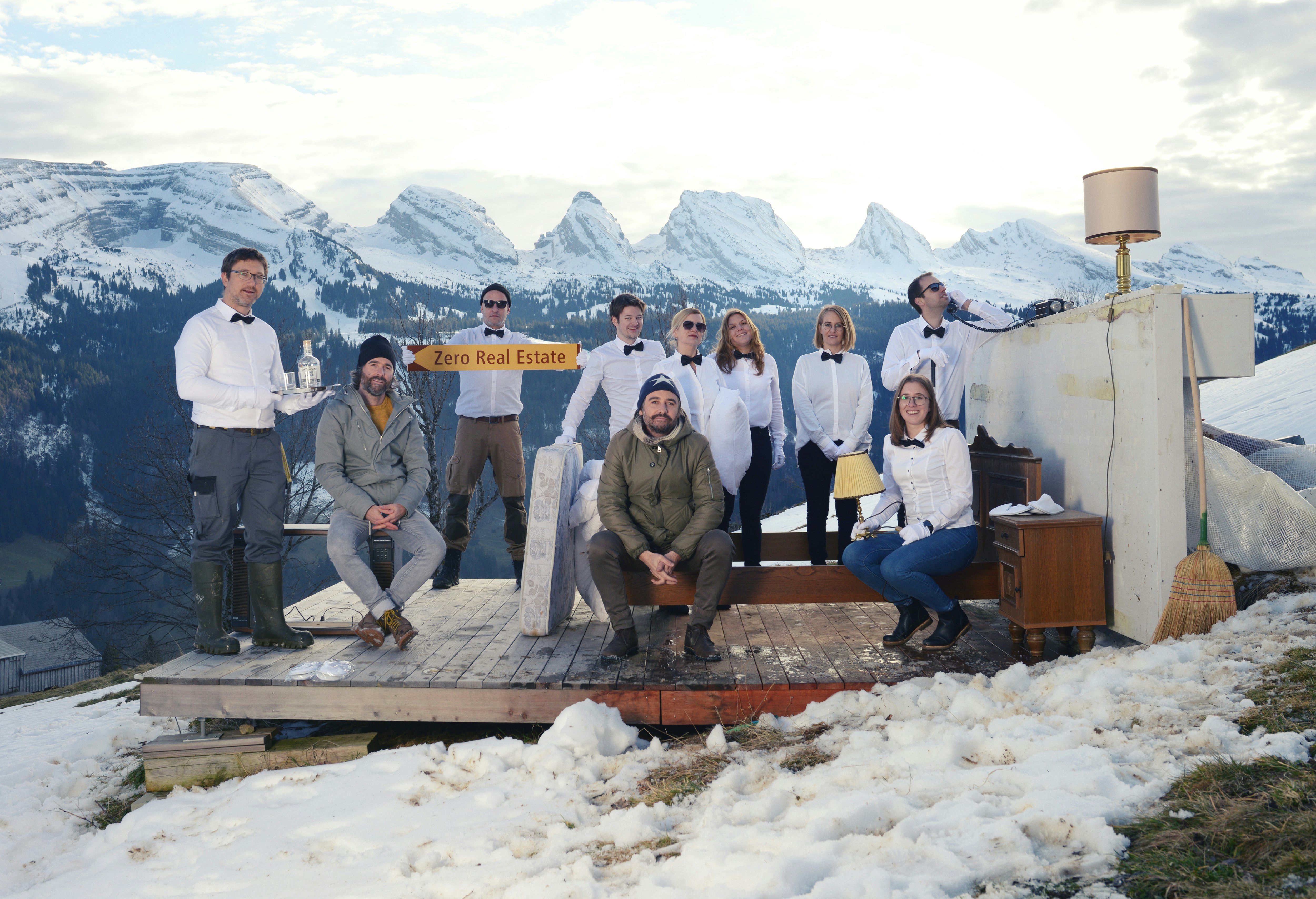 A group of people stand by a bed in the snowy Swiss Alps