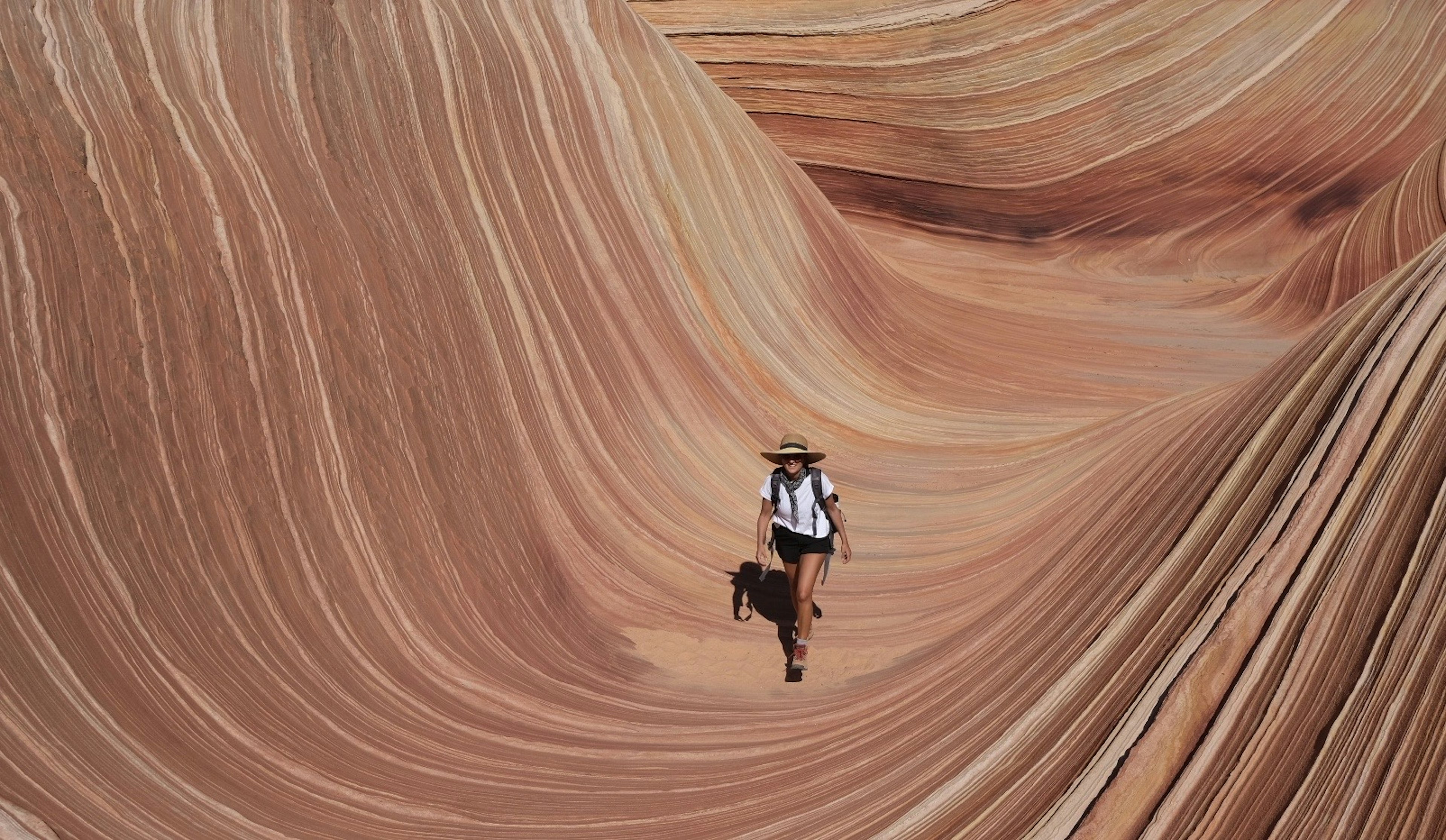 A woman walking toward the camera in a deep sandstone trough