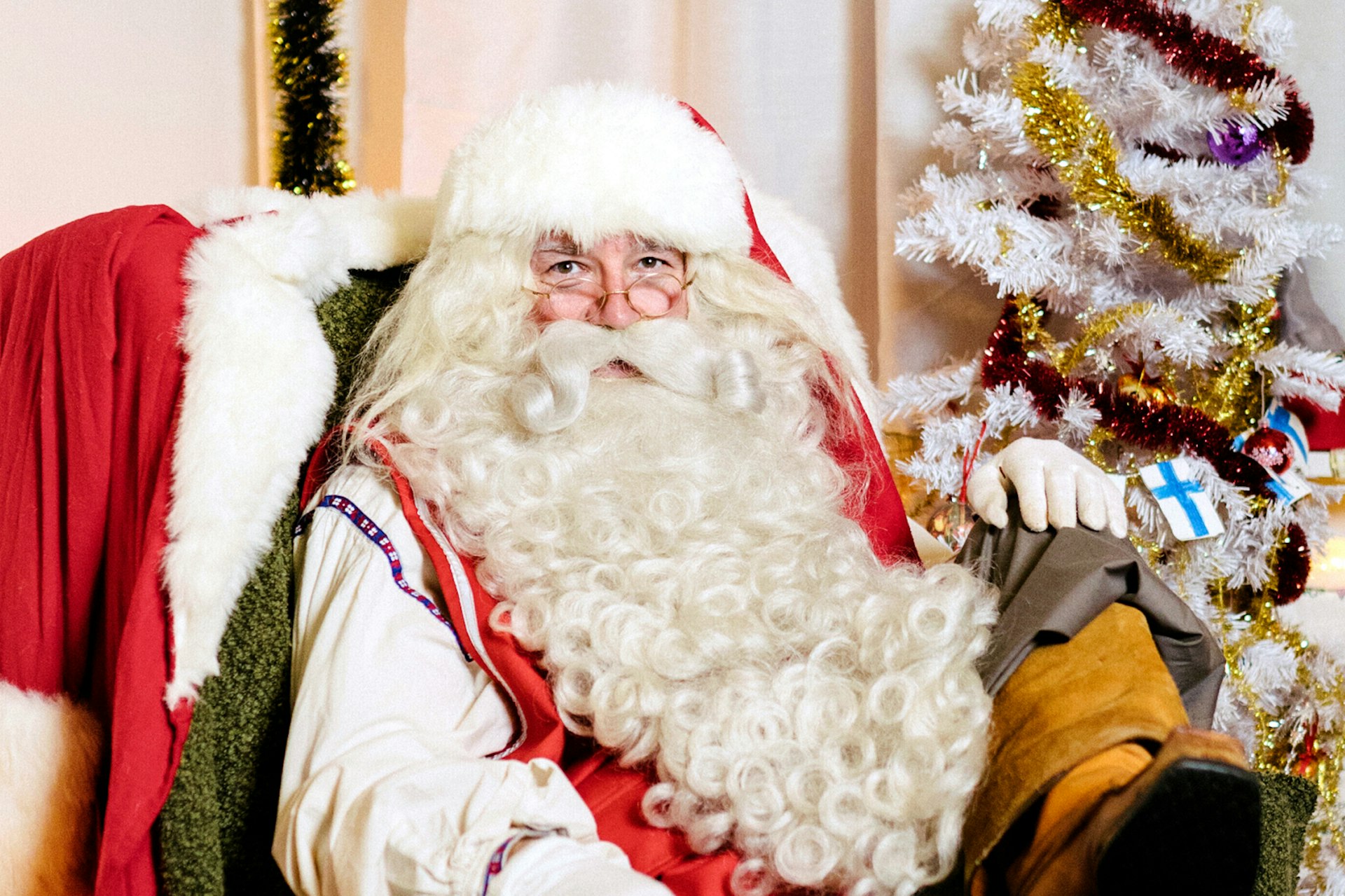 A picture of Santa Claus aittig on his throne