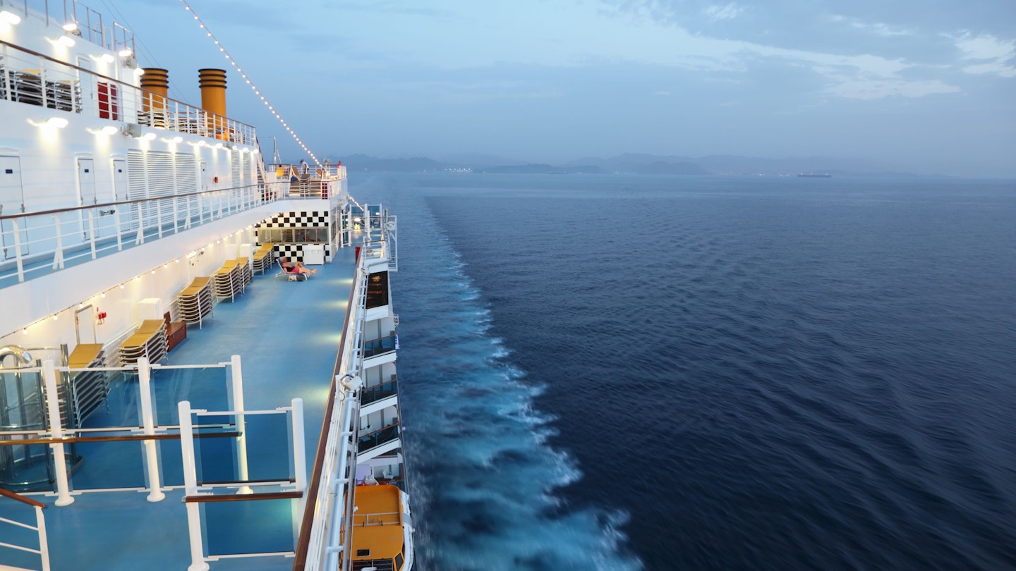 The deck of a cruise ship during the evening.