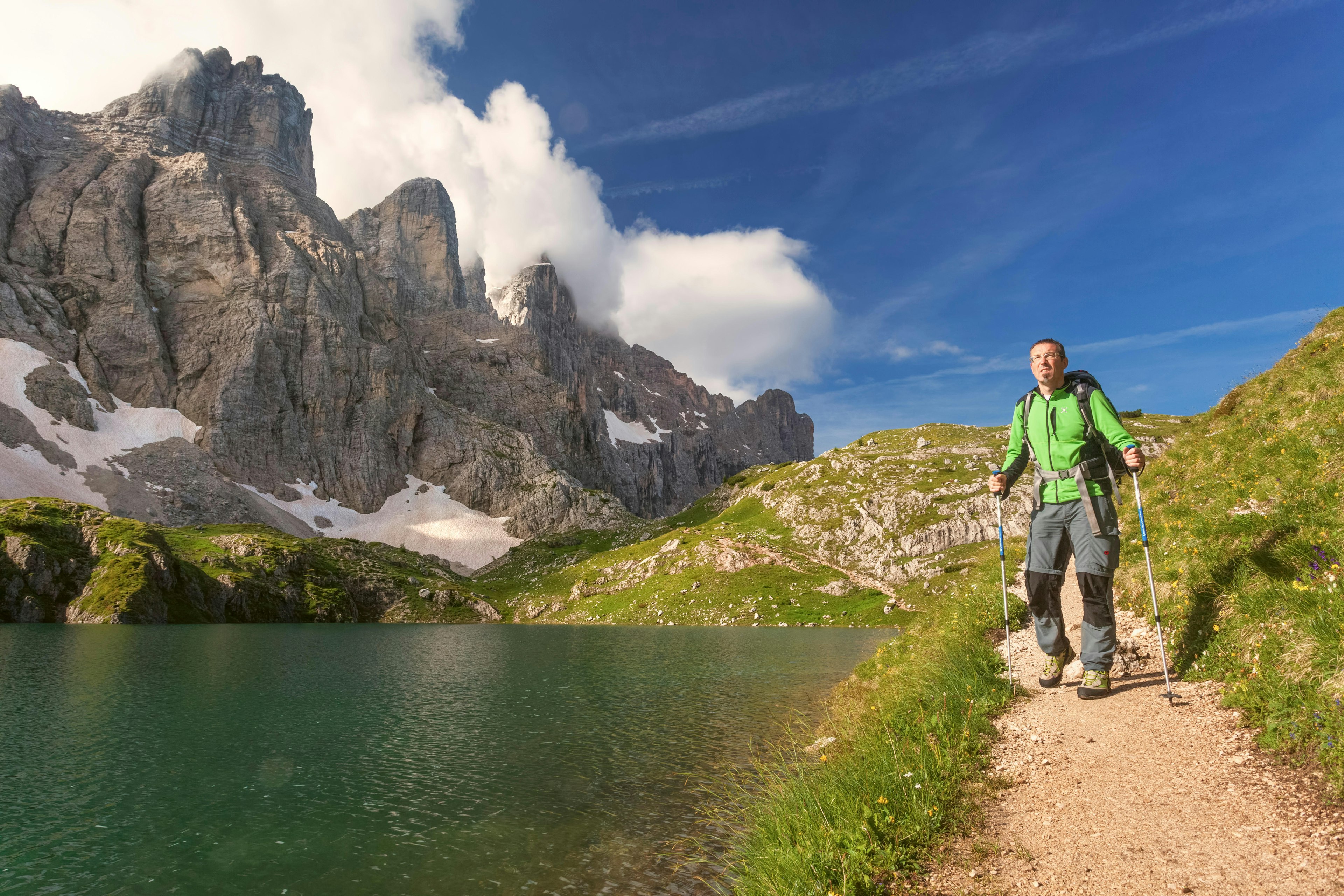 Male hiker passes near Lake Coldai along the CAI 560, which at this point coincides with the Alta Via N1.