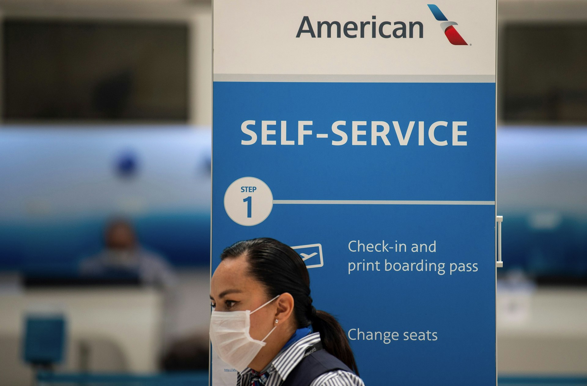 A masked American Airlines staffer waits for customers in the airport